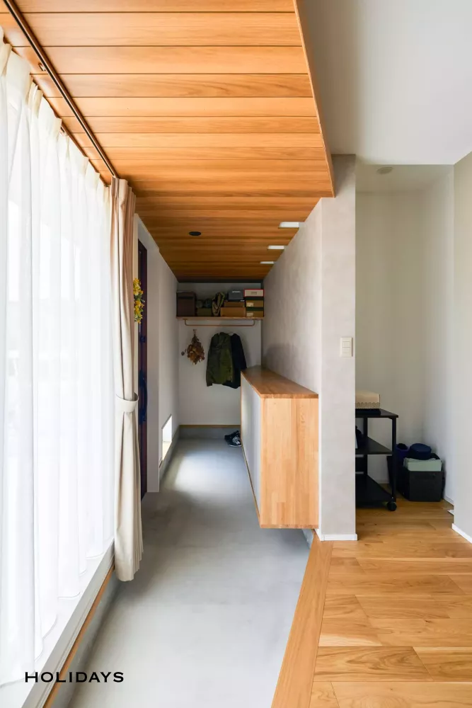 玄関框は斜めデザインとし、土間をモルタル仕上げとすることで、ノイズレスな空間になっている。