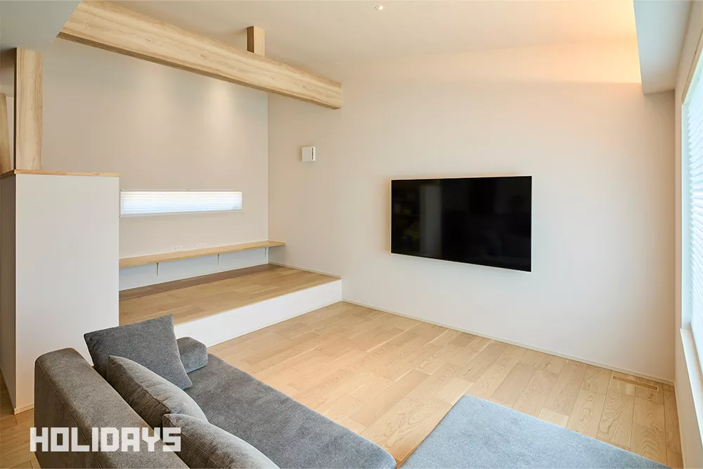 リビングの中には小上がりコーナー設計。変化と立体感が生まれ、インテリアとしてもメリハリのある空間に仕上がった。ドアなどの仕切りがなくても段差によって視覚的に空間を分けることができる為、リビングと共存しながらも子供のプレイルームや勉強部屋、団らんスペース等、家族の生活スタイルに合わせた多目的な利用が可能に。