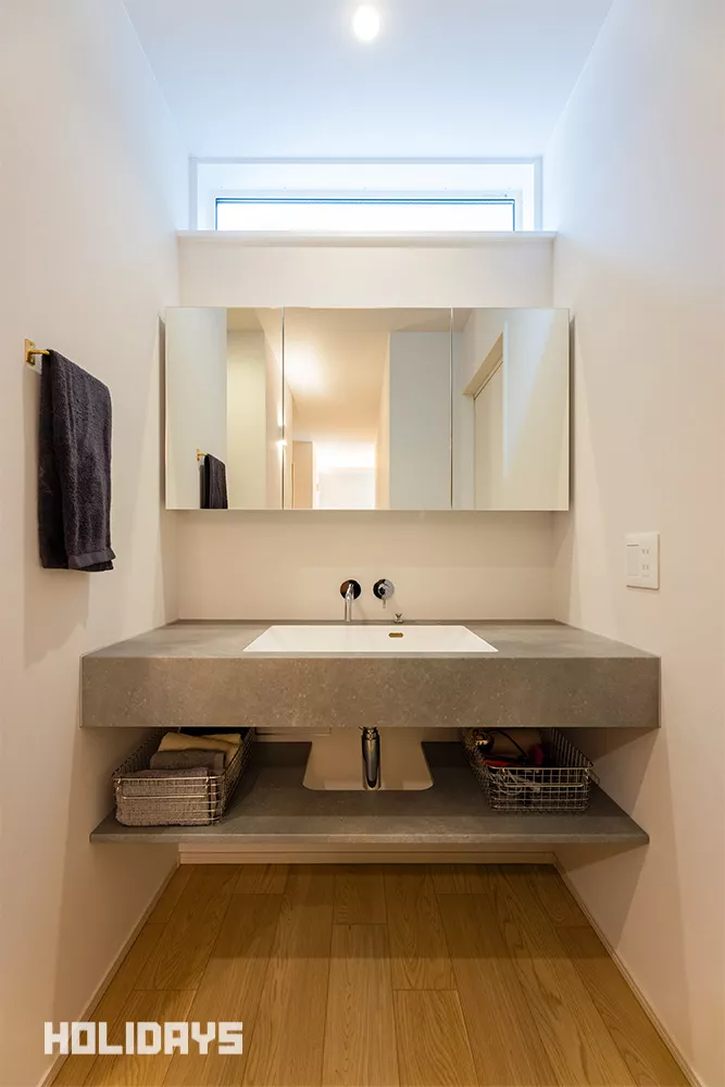 玄関ホールに設けた造作洗面は、室内のドアを触る前に手を洗えるため衛生的で、お子様の手洗い習慣にも最適な間取り。また洗面はフロートタイプにし、壁出しの水栓にモルタル調のカウンターを組み合わせることでよりスタイリッシュに。